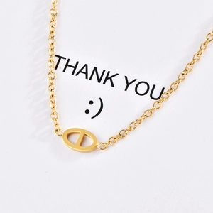Elegant gold-tone pig nose link pendant necklace on minimalist thin cross chain
