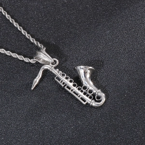 Detailed close-up of a silver saxophone pendant necklace made of polished stainless steel