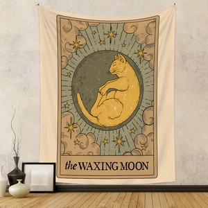 Detail of bohemian tarot tapestry featuring a ginger cat inside a waxing moon on a wall