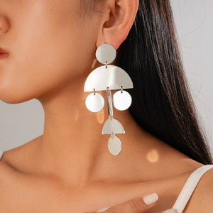 Primo piano di una modella con orecchini geometrici rotondi in argento a pendente lungo