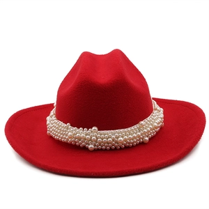 Detail of red wool felt fedora featuring tiered rows of elegant pearl embellishments