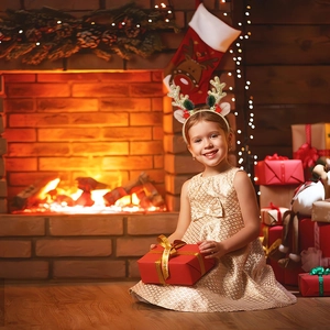 Detail view of a child wearing a golden glitter reindeer antler headband with bells