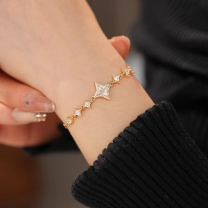 Detail of elegant gold star bracelet featuring pavé zircon star charms on female wrist