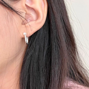 Close-up of minimalist sterling silver hoop earring with single pearl on female model