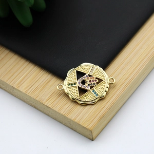 Detail of 18K gold-plated Hamsa Hand connector with colorful zircon on wood background