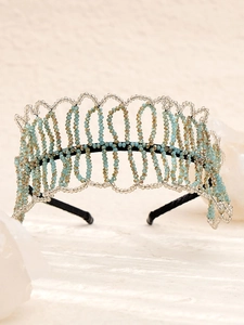 Detailed view of handmade beaded headband with blue and champagne crystals on black base