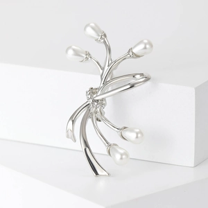 Vue macro de la broche branche argentée avec cinq perles d'imitation blanches et strass