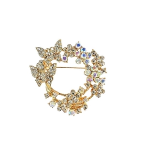 Elegant gold butterfly and floral brooch with crystals on a white background