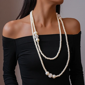 Close-up of double-layer faux pearl necklace with sparkling rhinestone spheres on model