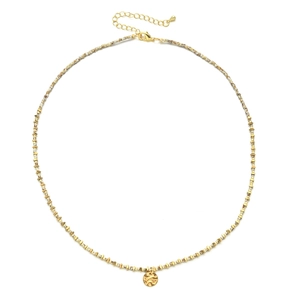 Detail of beaded necklace with golden hammered coin pendant and toggle clasp