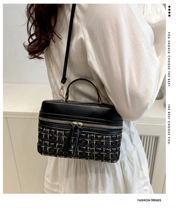 Detail of crossbody box bag with black PU leather and gold-woven tweed texture