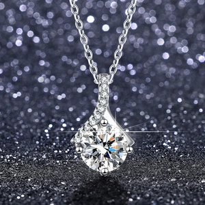 Macro shot of a brilliant moissanite pendant with a four-prong setting and pavé accents