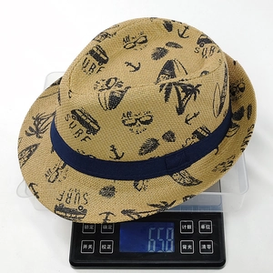 Dettaglio di un cappello di paglia SURF stampato su una bilancia che mostra il suo peso