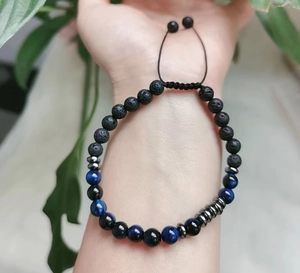 Macro detail of beaded Morse code bracelet with blue tiger eye stone and black lava beads