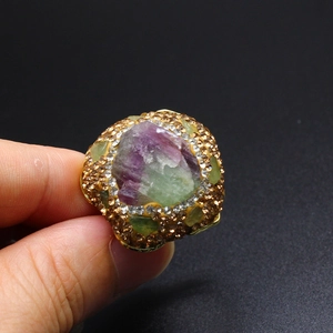 Close-up of vintage gold ring with gradient purple crystal stone and sparkling rhinestones