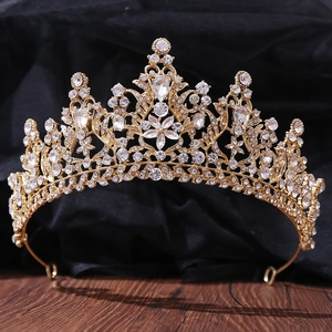 Detailed view of luxury bridal tiara featuring gold flower patterns and crystal rhinestones