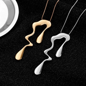Detailed close-up of fluid liquid-style abstract pendants in gold and silver finishes