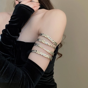Detail view of multi-layer hammered metal upper arm cuff on a model wearing black velvet