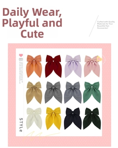 Flat lay of 12 colorful satin bow hair clips in vibrant shades like orange and emerald