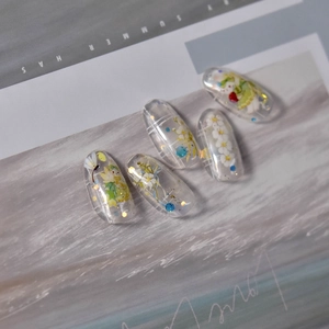 Close-up of thin floral nail art stickers with delicate yellow flowers and summer patterns