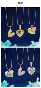 Detail view of gold and silver heart pendants with cubic zirconia on blue velvet
