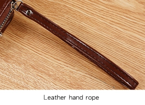 Close-up of a dark brown leather hand strap with neat stitching and silver metal clasp