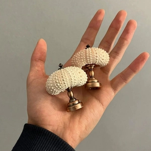 Close-up of mini sea urchin night light with white shell and vintage bronze base