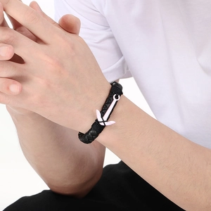 Close-up of a men's black braided leather bracelet featuring a metal anchor magnetic clasp