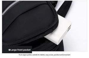 Detailed view of the large front zipper pocket on this black crossbody bag for iPad storage