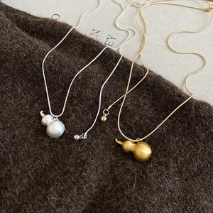 Dettaglio della collana con pendente a zucca opaca e catena a serpente in oro e argento