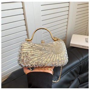 Close-up of sparkling silver sequin evening bag with gold metal handle and chain strap
