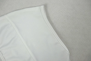 Close-up of white knit fabric texture and high-quality hemmed seam stitching details