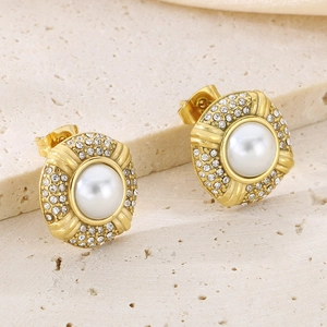 Macro shot of 18k gold oval stud earrings with white pearl and micro-pave crystals