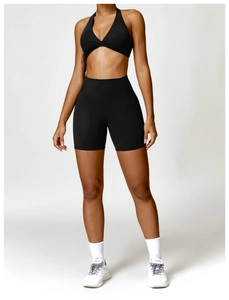 Detail of high-stretch black yoga set featuring twist-knot sports bra and high-waist shorts
