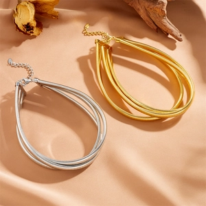 Ensemble de colliers multi-rangs en or et argent sur un fond élégant en soie beige