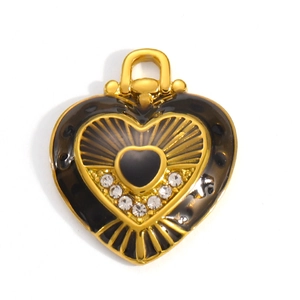 Macro detail of heart charm with black enamel, gold rays and sparkling rhinestones