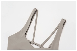 Detail of cross-back thin straps on grey yoga sports bra with high-elastic fabric