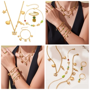 Détails d'un ensemble de bijoux dorés avec pendentifs hippocampe et étoile de mer