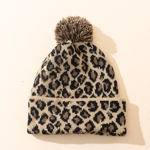 Close-up of leopard print knit beanie featuring a soft faux fur pom-pom detail