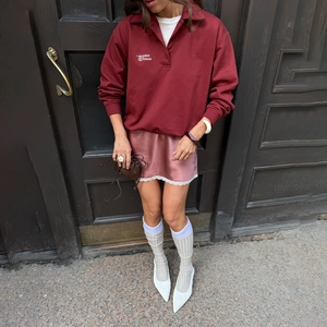 Détail d'une mini-jupe en satin à taille haute avec bordure en dentelle blanche et soie rose