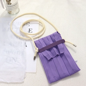 Detail view of purple pleated knitted mini phone bag with white knotted shoulder strap