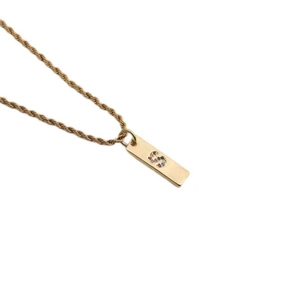 Detail of gold twist chain and rectangular pendant with colorful zircon letter S
