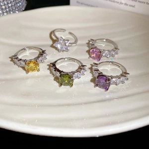 Detailed view of five adjustable silver rings with colorful star and round zircon stones