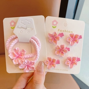 Detailed view of pink cherry blossom hair clips and elastic tie set with floral resin details