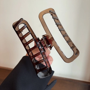 Detail view of a large amber acetate hair claw clip with sturdy metal spring mechanism
