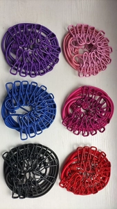 Overhead view of various portable elastic clotheslines with clips in multiple colors
