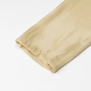 Detailaufnahme des goldenen Satin-Kleidärmels mit hochwertiger Naht und Textur