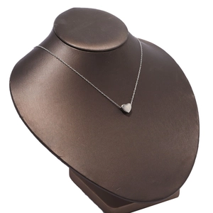 Detailed view of a silver heart pendant necklace on a jewelry display bust