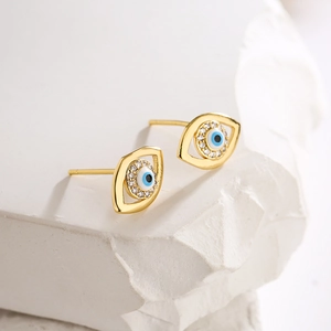 Macro shot of 18K gold plated evil eye stud earrings with blue enamel and sparkling zircons