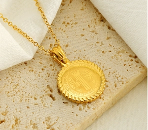 Detail of St. Benedict gold medallion on beige stone with intricate Latin engravings